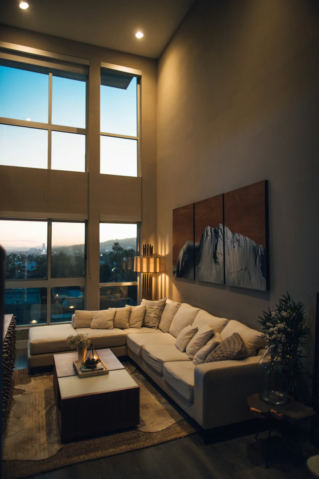 Sala de una vivienda con iluminación cálida y ventanales